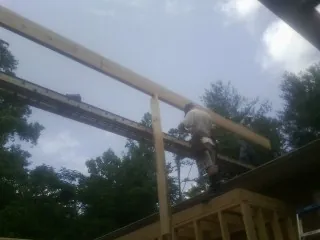 Carpenter setting a ridge beam over a new addition frame — Ice Dam Removal by Roofing Brothers in Queenstown