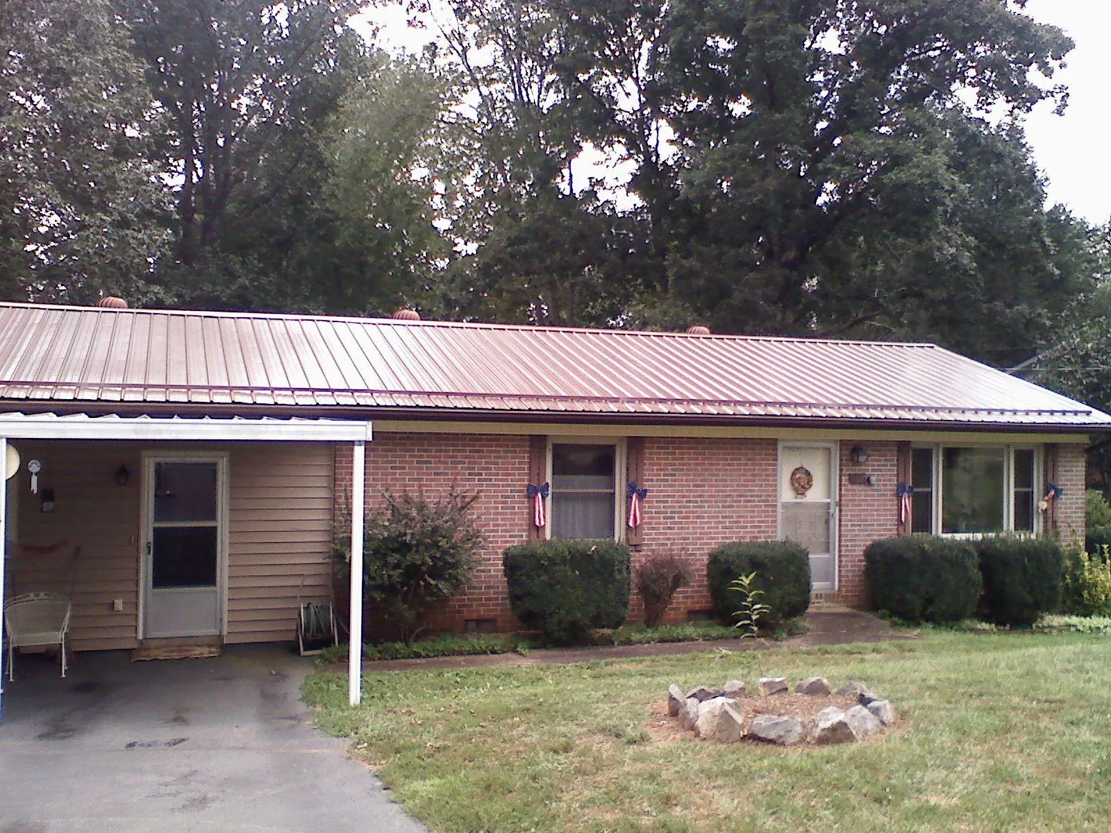 Bronze metal roof and carport on a brick ranch home — Roof Repair work by our crew in Queenstown